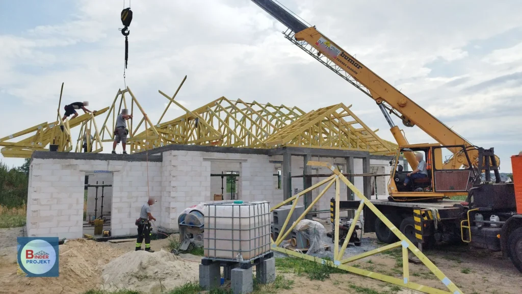 Widok konstrukcji dachu z wiązarów podczas ich montażu.