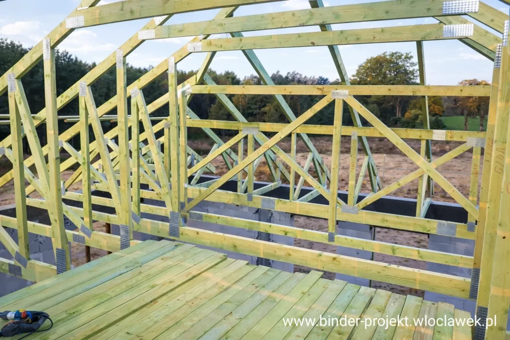 Pomieszczenie strychowe z podłogą drewnianą i konstrukcją dachu z prefabrykowanych wiązarów